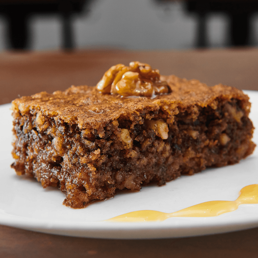 A slice of walnut karidopita with a walnut garnish