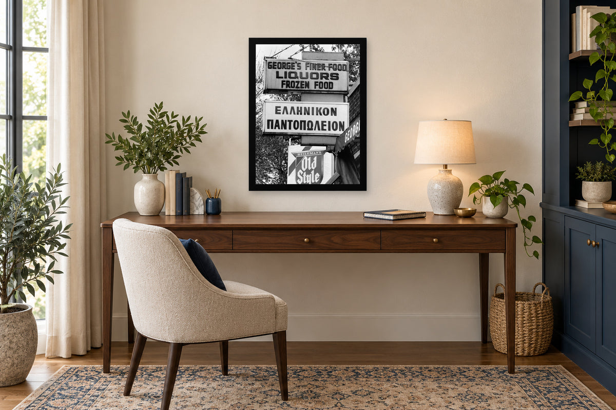 George’s Greek Grocery in a black frame, shown in an office setting — room visualization