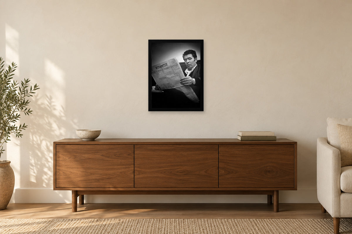 Reading the Greek Newspaper in a black frame, shown in a home setting — room visualization