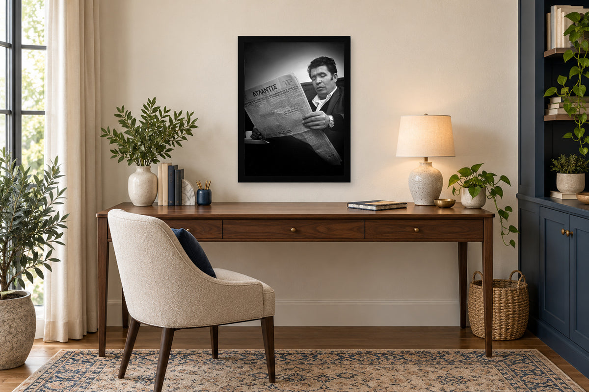 Reading the Greek Newspaper in a black frame, shown in an office setting — room visualization