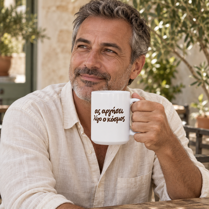 AI-generated lifestyle image: man enjoying coffee in a courtyard with the Ας Αργήσει Λίγο ο Κόσμος white 15 oz mug